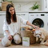 Vivus Green laundry box with laundry basket and dog in front of  washing machine.