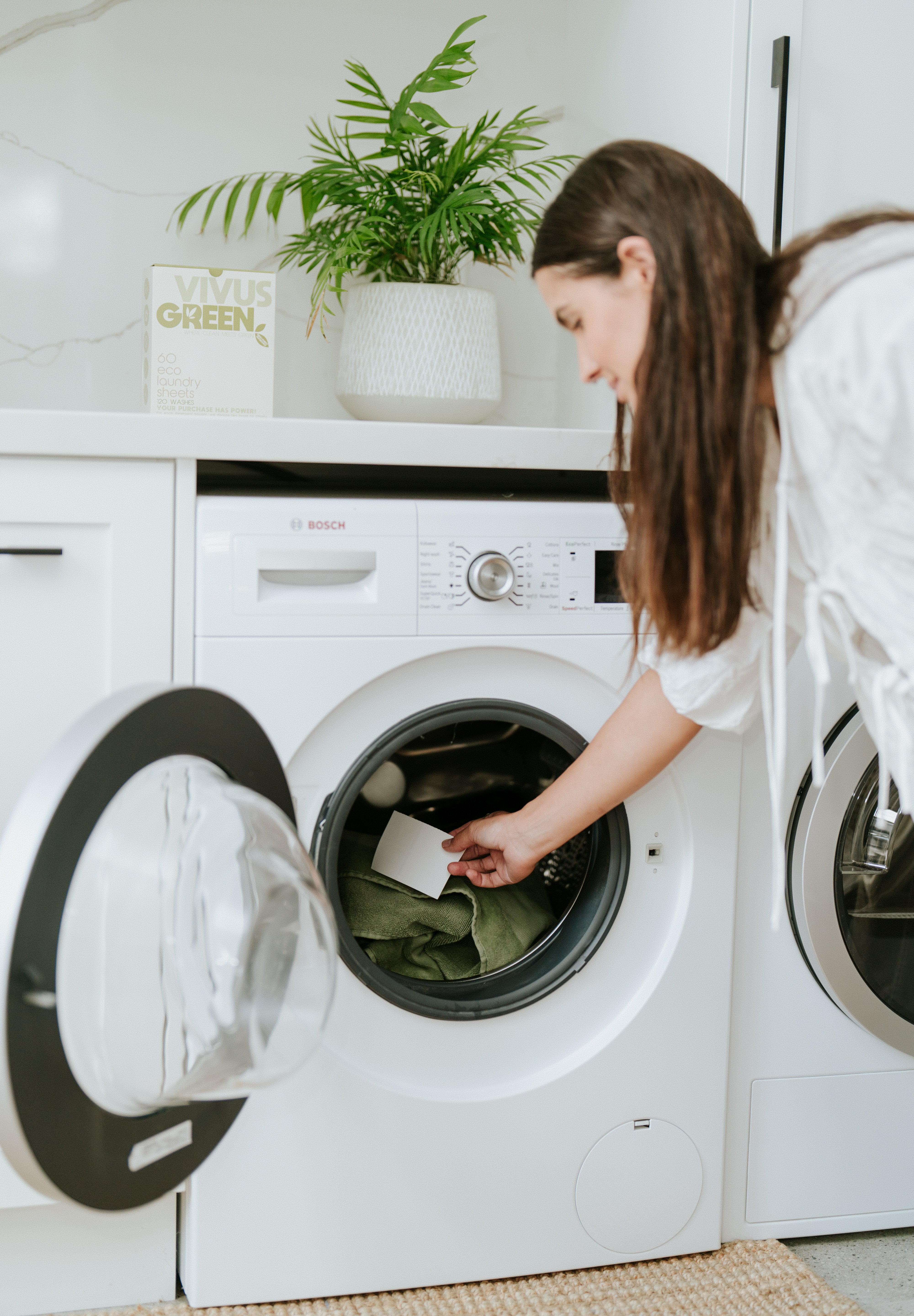 Placing of Vivus Green laudry sheet into a front loading washing machine.